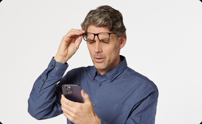 hombre présbita usando gafas para ver el móvil